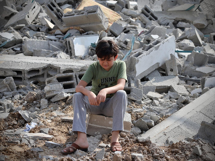 A boy next to the ruins of a building in Gaza city that was hit by a rocket.